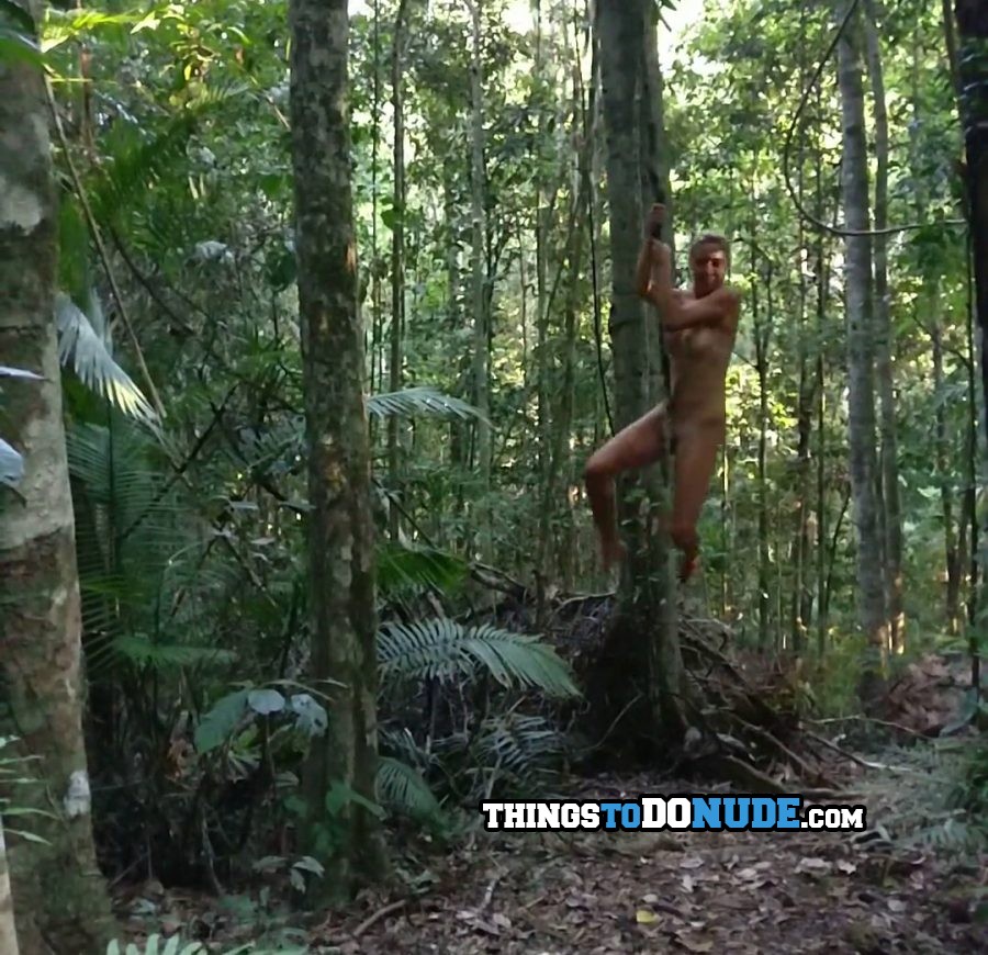 Hot nude girl swinging on a vine from a big tree